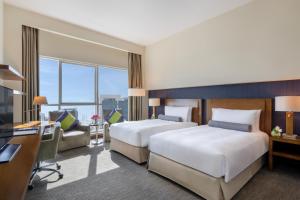 Grand Millennium Al Wahda Hotel and Executive Apartments Abu Dhabi客房内的一张或多张床位