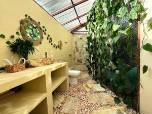 a bathroom with a toilet and a green wall at Jungle Circle Uluwatu in Uluwatu +17 photos