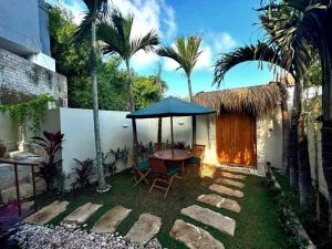 a patio with a table and umbrella in a yard at Jungle Circle Uluwatu in Uluwatu