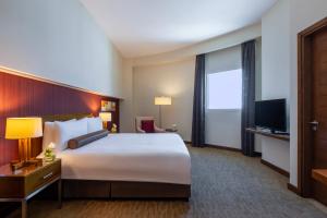 Grand Millennium Al Wahda Hotel and Executive Apartments Abu Dhabi客房内的一张或多张床位