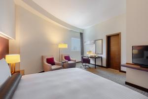 Grand Millennium Al Wahda Hotel and Executive Apartments Abu Dhabi的电视和/或娱乐中心