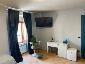 a bedroom with a bed and a desk and a window at B&B Popoli Terme in Popoli