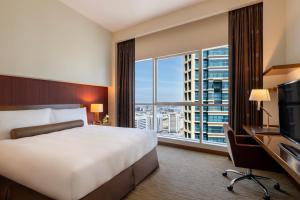 Grand Millennium Al Wahda Hotel and Executive Apartments Abu Dhabi的电视和/或娱乐中心