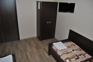 a bedroom with a bed and a flat screen tv at Hotel Gościniec in Włocławek