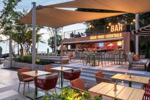 an outdoor patio with tables and chairs and a bar at Holiday Inn Pattaya by IHG in Pattaya +250 photos