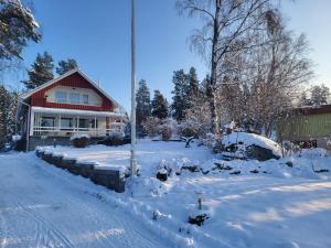 a snow covered yard with a house in the background at Big 4 bedroom house with sauna by the sea in Vaasa