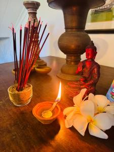 a table with a candle and flowers on it at Coastal Cloud Backpackers in Unawatuna