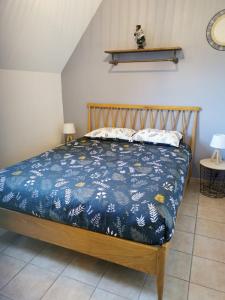 a bedroom with a bed with a blue comforter at Le N5 des Hauts de Sarlat Apt Duplex Clim, Piscine, Parking in Sarlat-la-Canéda +25 photos