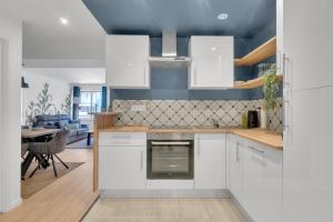 une cuisine avec des placards blancs et une salle à manger dans l'établissement Le Charles Roissard - Proche Gare, à Chambéry