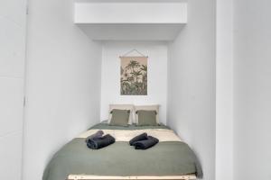 un lit dans une chambre blanche avec deux oreillers dans l'établissement Le Charles Roissard - Proche Gare, à Chambéry