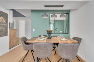 une salle à manger avec une table et des chaises en bois dans l'établissement Le Charles Roissard - Proche Gare, à Chambéry 7 autres photos