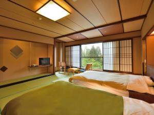 美作Yunogo Onsen HOTEL YUNOMORI BISYUNKAKU的一间卧室，配有一张大床和一扇窗户。 更多79张照片