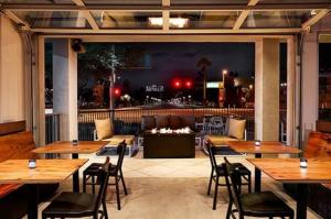 a restaurant with wooden tables and chairs and a couch at Graduate by Hilton Tempe in Tempe