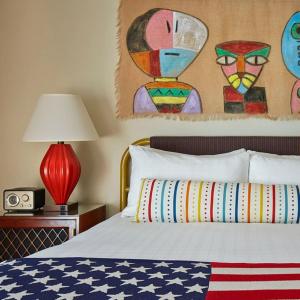 a bedroom with a bed with a red lamp and a painting at Graduate by Hilton Tempe in Tempe