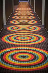 a carpeted hallway with a colorful carpeted floor at Graduate by Hilton Tempe in Tempe