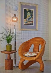 a wooden chair sitting next to a table with a lamp at Graduate by Hilton Tempe in Tempe