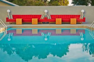 a red couch sitting next to a swimming pool at Graduate by Hilton Tempe in Tempe