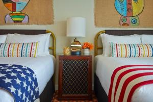 two beds sitting next to each other in a bedroom at Graduate by Hilton Tempe in Tempe