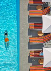 a person swimming in a swimming pool at Graduate by Hilton Tempe in Tempe