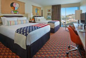 a hotel room with two beds and a desk at Graduate by Hilton Tempe in Tempe