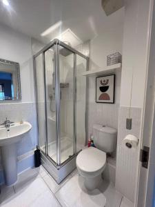 ein Badezimmer mit Dusche, Toilette und Waschbecken in der Unterkunft Cosy 2 Bed Service Apartment Netflix Hideaway Family Couples Staycation Tredegar Park Celtic Manor ICC Wales in Lower Clapton
