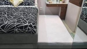a bedroom with a bed with a black and white comforter at AGC Penthouse - Ground Floor Apartment in Zamboanga