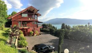 uma casa com um carro estacionado em frente em La Merle em Veyrier-du-Lac