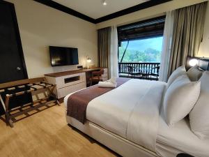 a hotel room with a bed and a television at Sebana Cove Resort in Pengerang +9 photos