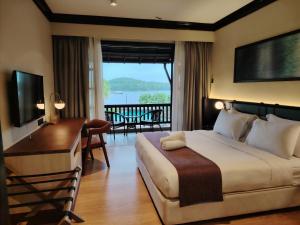 a hotel room with a bed and a desk and a computer at Sebana Cove Resort in Pengerang