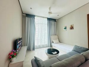 ein Wohnzimmer mit Couch und großem Fenster in der Unterkunft Soho Suites KLCC By Grand Suites KL in Kuala Lumpur + 55 Fotos