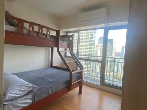a bedroom with a bunk bed with a view of a city at The Home Ikigai in Manila +77 photos