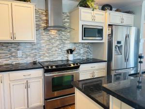 a kitchen with white cabinets and stainless steel appliances at Blue Sunset in Holden Beach
