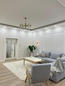a living room with a couch and a table at Scandinavian Style Apartment in Fergana