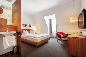a hotel room with a bed and a sink at Hotel am Jakobsmarkt in Nuremberg