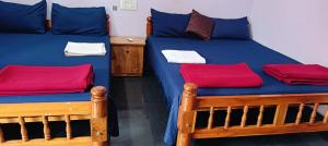 two beds in a room with red and blue sheets at Parshuram Sea Shore Cafe and Rooms, Gokarna in Gokarn +44 photos