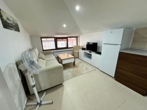 a living room with a couch and a refrigerator at Belvedere Holiday Club nice place in Bansko