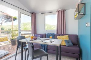 Domaine de l'Epinette في Châtillon: غرفة معيشة مع طاولة وأريكة أرجوانية