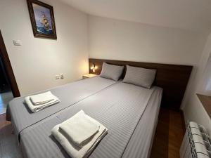 a bedroom with a large bed with towels on it at Belvedere Holiday Club nice place in Bansko +27 photos