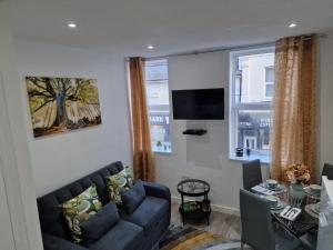 a living room with a couch and a tv at 12 B Market Street in Watford