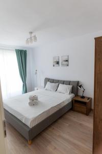 a bedroom with a large bed with white sheets at Apart B&V 706 Coresi - Balcony & Free Parking in Braşov