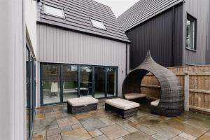a patio with a chair and ottoman next to a building at The Country Toll Bar Farmhouse in Grimsby