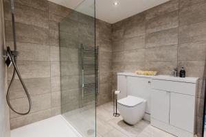 a bathroom with a shower and a toilet at The Country Toll Bar Farmhouse in Grimsby +11 photos