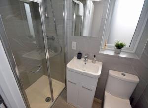 a bathroom with a shower and a toilet and a sink at Walton Suites in Watford +9 photos