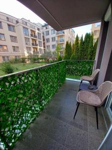 a balcony with two chairs and a fence at Аpartment Van Gogh in Hisarya