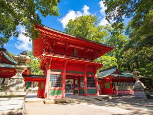 a red building in a park with trees in the background at FLEXSTAY INN Kashima Central in Kamisu