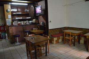 un restaurante con mesas, sillas y TV en Argo Hotel en Atenas