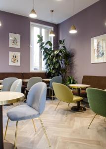 a waiting room with tables and chairs at Hôtel le XIX in Béziers