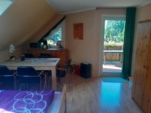 a room with a table and chairs and a large window at FeWo Hohen Neuendorf bei Berlin mit Sauna und Fuß-SPA in Hohen Neuendorf