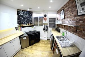 a kitchen with a sink and a brick wall at Central Backpackers in Oxford