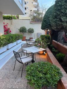 a patio with a table and chairs and a tree at Hotel Maroussi in Athens